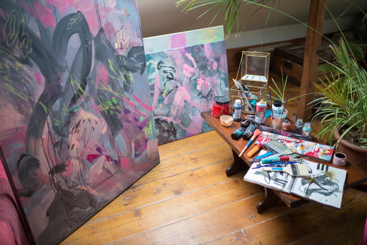 A vibrant art studio showcasing abstract paintings and artist tools, inspiring creativity.